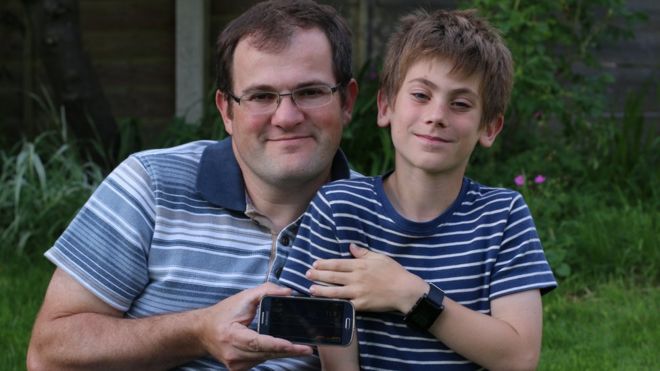 Alistair Samuelson and George with their phone and smartwatch