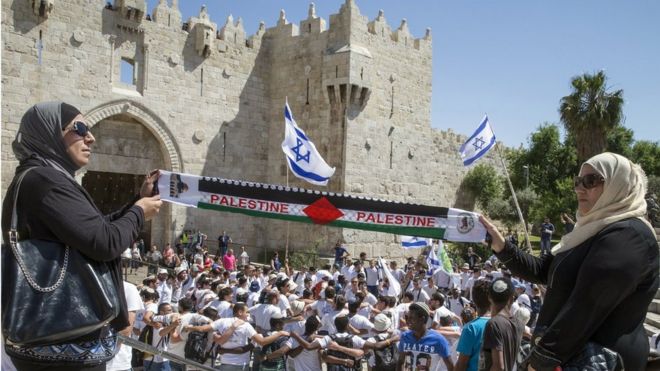 Palestinian women hold 'Palestine' scarf in front of pro-Israel rally in Jerusalem (file photo)