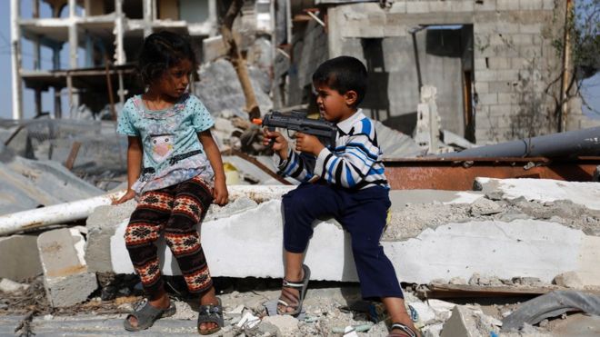 Niño apunta con pistola de juguete a niña