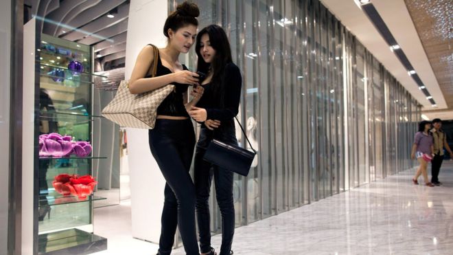 Vietnamese fashion model Van Doll (L) hangs out with a fellow model in a new shopping mall February 24, 2011 in Ho Chi Minh City, Vietnam