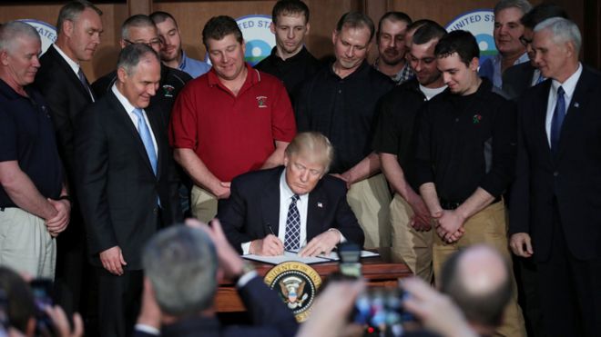 Mr Trump signed the order while flanked by coal miners