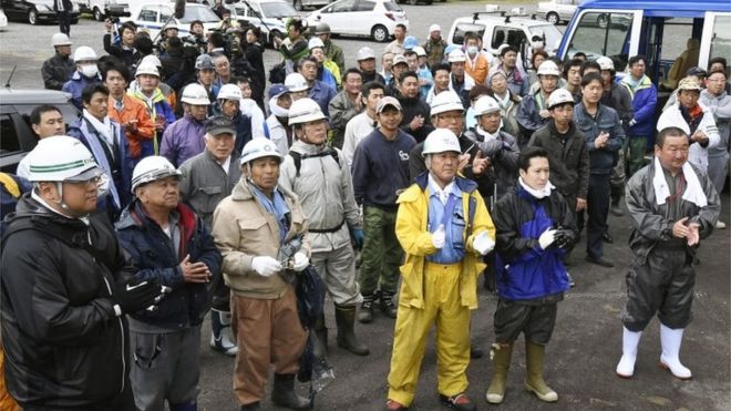 Rescue teams in Hokkaido celebrate the news a boy has been found (3 June 2016)