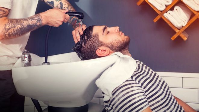 Hombre lavándose el pelo en la peluquería