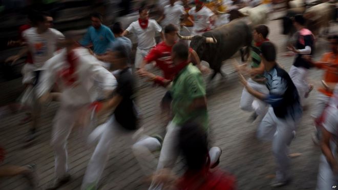 Revellers running with the bulls in Pamplona, Spain (14 July 2015)
