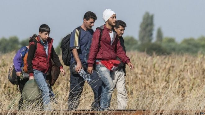 Migrants walk at the railway crossing at the border between Hungary and Serbia near Roszke - 25 August 2015