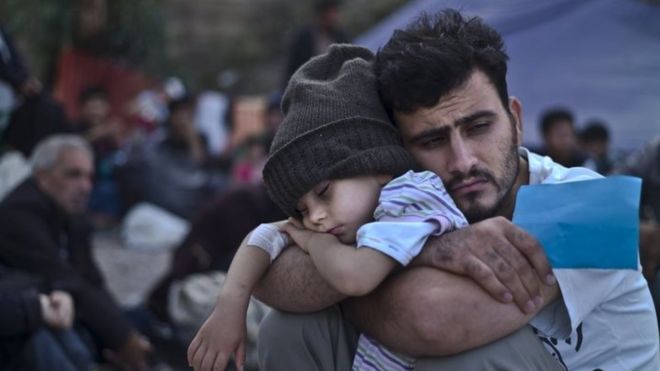 A Syrian migrant child sleeps on his father's arms on the Greek island of Lesbos. Photo: 4 October 2015