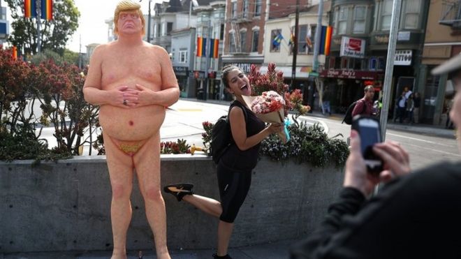 A woman has a picture taken next to a Donald Trump in San Francisco