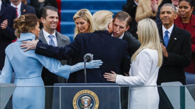 President Trump is congratulated by his family after taking the oath of office, as former President Obama and his wife Michelle look on