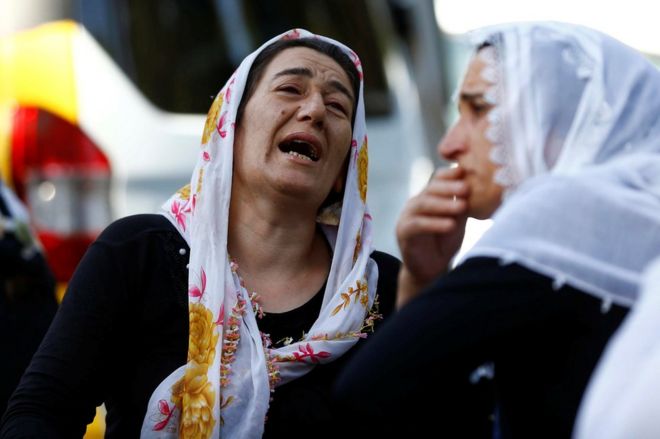 Women wait outside a morgue in the Turkish city of Gaziantep, 21 August