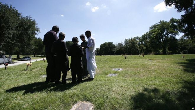 A family gathers in prayer as they visit an Islamic garden in Restland cemetery, Dallas - 17 July 2015