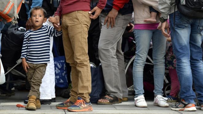 Migrants wait for a special train to Berlin at the train station in Munich, southern Germany, on September 13, 2015.