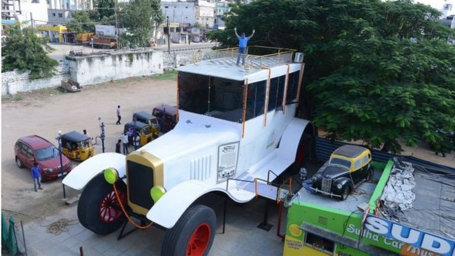 Indian car designer Sudhakar Yadav poses on the top of a large stationary car - modelled on the 1922 Ford Tourer - at the Sudha Cars Museum in Hyderabad on October 6, 2015.