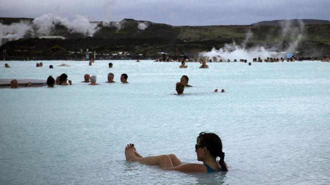 People bath in the 'Blue lagoon ' geothermal spa, one of the most visited attractions in Iceland