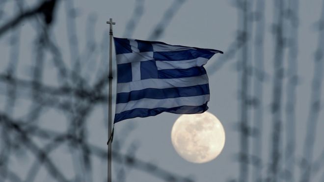Bandera de Grecia frente a una gran Luna llena en Atenas