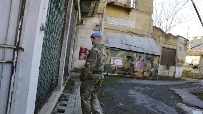 a UN soldier walks by an abandoned Turkish military guard post inside the UN buffer zone, Green Line