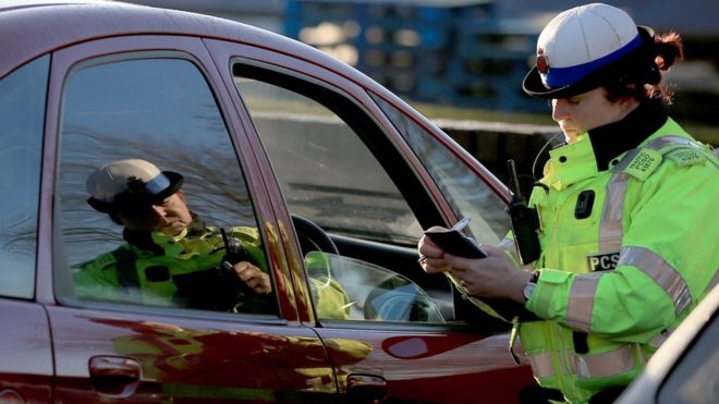 A policewoman stopping a driver