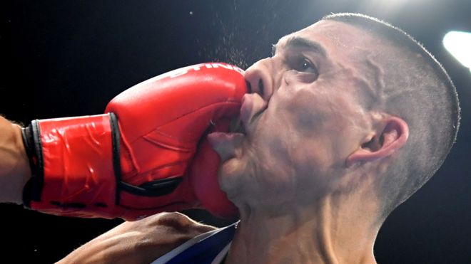 Teófimo López Rivera con el rostro contorsionado tras ser alcanzado por el puño de su rival francés