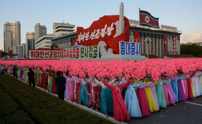 People holding up flowers during the military parade for the 70th anniversary of the founding Workers' Party, Pyongyang, North Korea - Saturday 10 October 2015