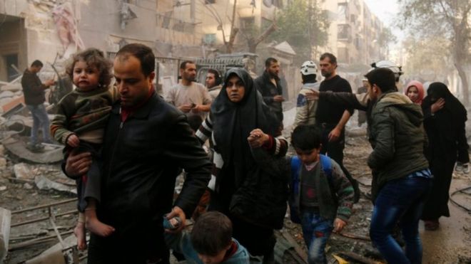Syrians make their way through debris as they leave for a safer place part of Aleppo in this January 2016 file picture