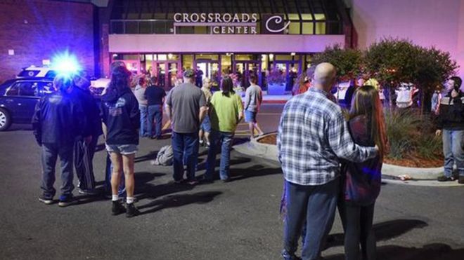 People stand near the entrance on the north side of Crossroads Center mall between Macy"s and Target as officials investigate a reported multiple stabbing incident, Saturday, Sept. 17, 2016, in St. Cloud, Min