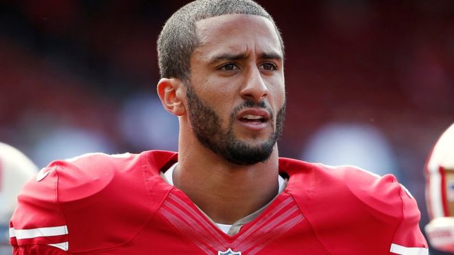 San Francisco 49ers quarterback Colin Kaepernick stands on the field before their NFL pre-season football game against the Denver Broncos