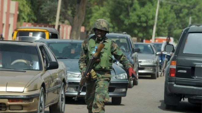 An officer of the Joint Military Task Force (JTF) walks on the road in the northeastern Nigerian town of Maiduguri, Borno State , on April 30, 2013.