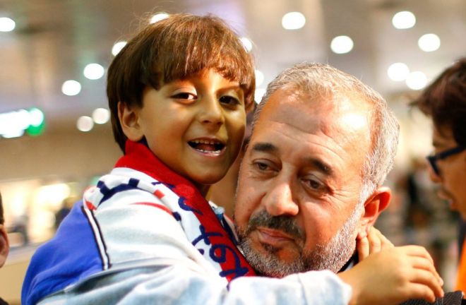 Syrian <b>Osama Abdul</b> Mohsen holds his son Zaid as they arrive at the Barcelona ... - _85589602_85589601