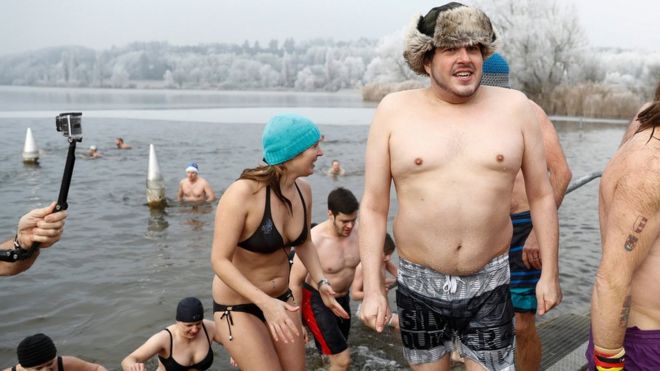 Swimmers come out of the four degree celsius cold water after the traditional New Year