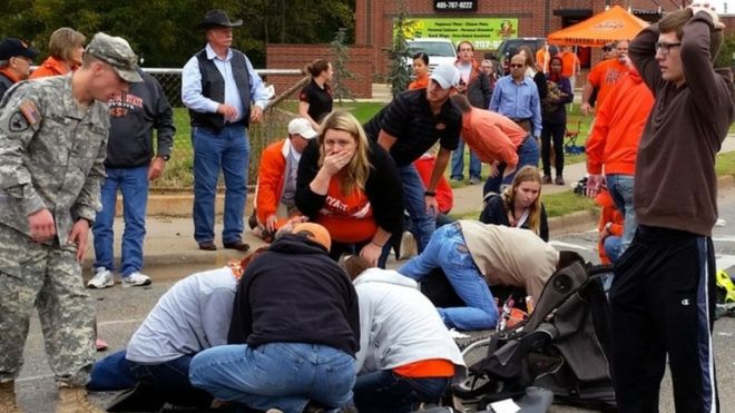 Bystanders help the injured after a vehicle crashed into a crowd of spectators during the Oklahoma State University homecoming parade (24 October 2015)
