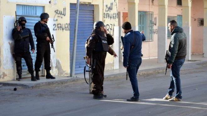 Tunisian police officers take positions during clashes with militants in Ben Guerdane