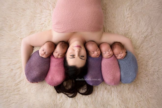 Kim Tucci lies on a rug with her quintuplets