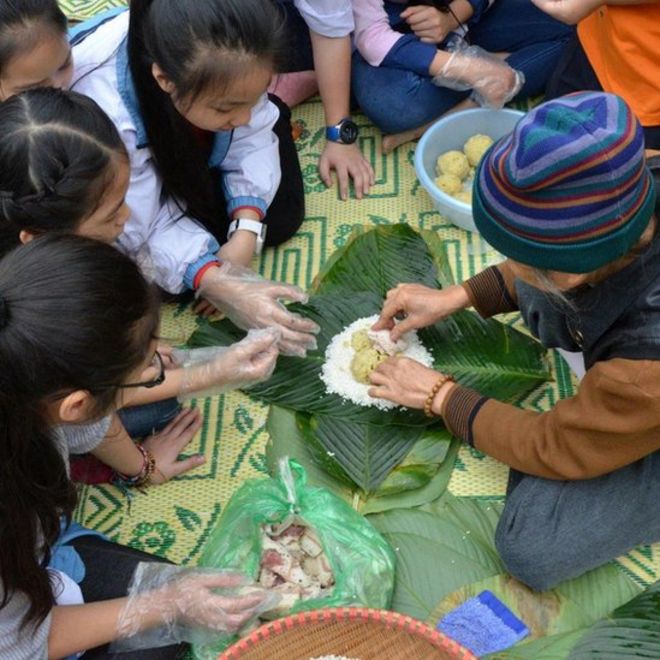 Trẻ em Việt Nam học cách gói bánh chưng Tết tại Bảo tàng Dân tộc học, Hà Nội