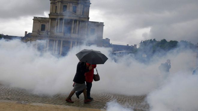Women walk through a fog of tear gas in Paris