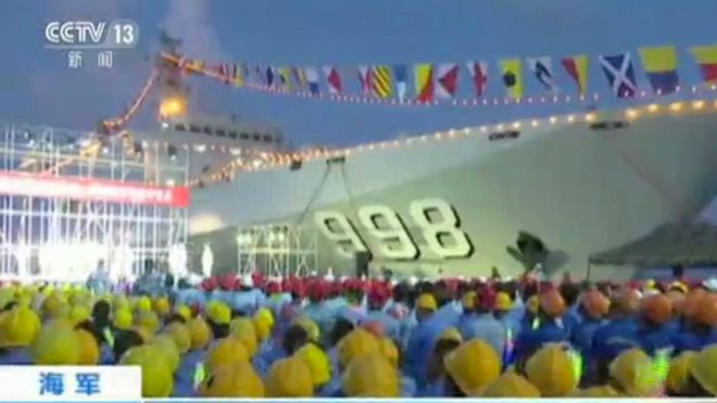 Blurry image taken from Chinese TV footage shows workers gathering near a Chinese military ship during a performance on Fiery Cross Reef in the South China Sea (May 2016)