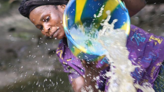 Woman scooping water (Image: Rachel Agnew/Rainforest Foundation UK)