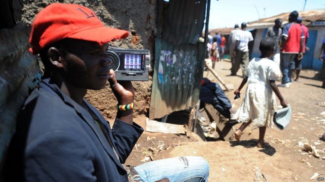 kenyan man listens to radio