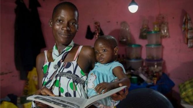 Woman reading to her baby under solar powered light