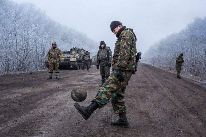 Ukrainian soldiers play football on the road leading to the embattled town of Debaltseve, 15 February 2015