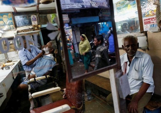 A man gets a shave inside a barber shop at a slum in Mumbai, India, August 3, 2016