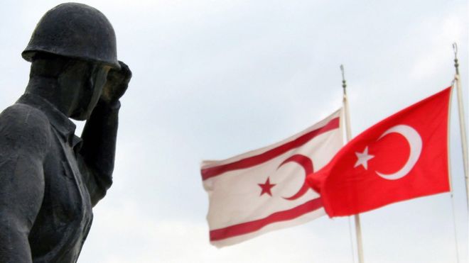 A soldier statue is seen with Turkish (R) and TRNC (self-proclaimed Turkish Republic of Northern Cyprus) flags 15 November 2006 in Nicosia