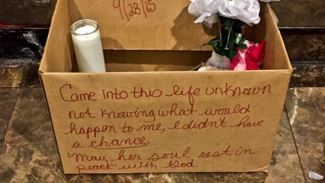 A makeshift memorial for a newborn who died after being tossed from a seventh floor apartment window, sits in the building's lobby, 30 September 2015, in New York