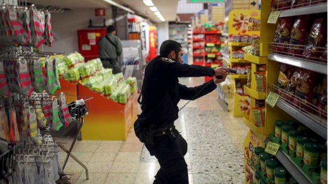 An Israeli policeman searches a supermarket inside the Central Jerusalem Bus Station after police said a woman was stabbed by a Palestinian outside the bus station October 14, 2015.