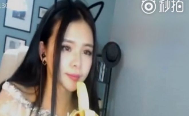 A screengrab from a live-streaming site of a woman holding a banana