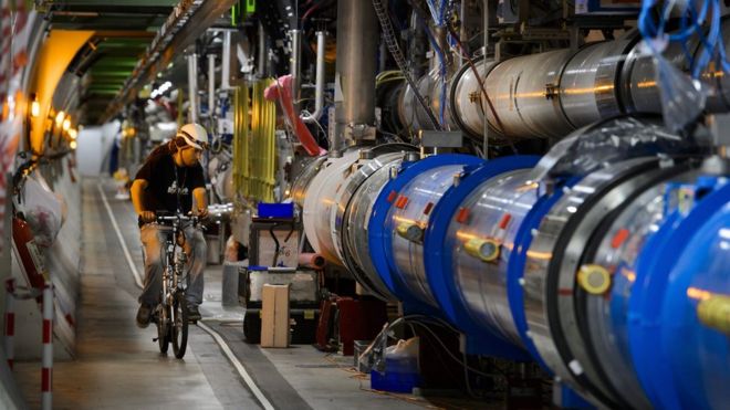 A worker rides his bicycle in a tunnel of the European Organisation for Nuclear Research (CERN) Large Hadron Collider (LHC), during maintenance works on July 19, 2013