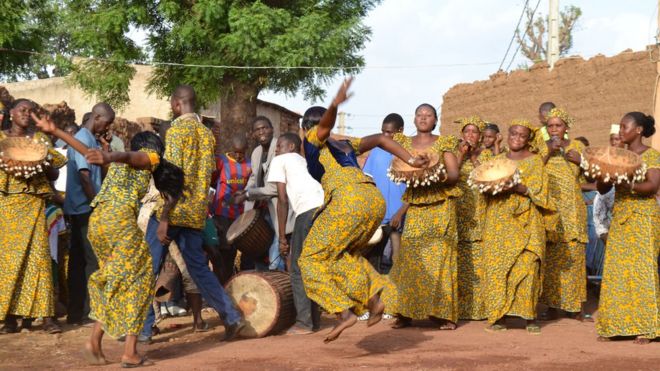 Young men and women dancing at a traditional celebration