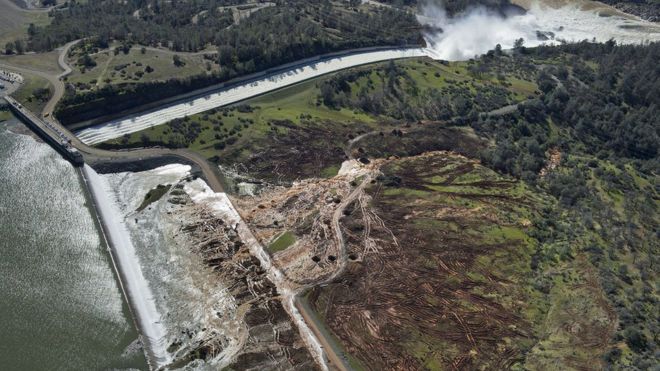 Water flows over the emergency spillway at Lake Oroville for the first time in the nearly 50-year history of the Oroville Dam, 11 February 2017