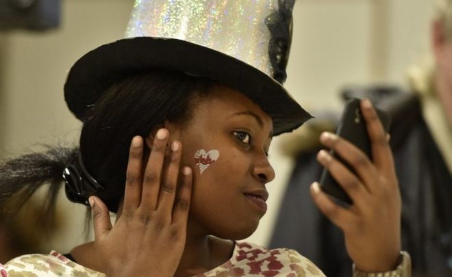 Sharon from Uganda checks her reveler's outfit during a carnival lecture for beginners, held by Caritas with the aim to bring Cologne lifestyle and carnival basics closer to refugees in Cologne