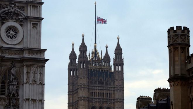 The flag above the Houses of Parliament flies at half mast