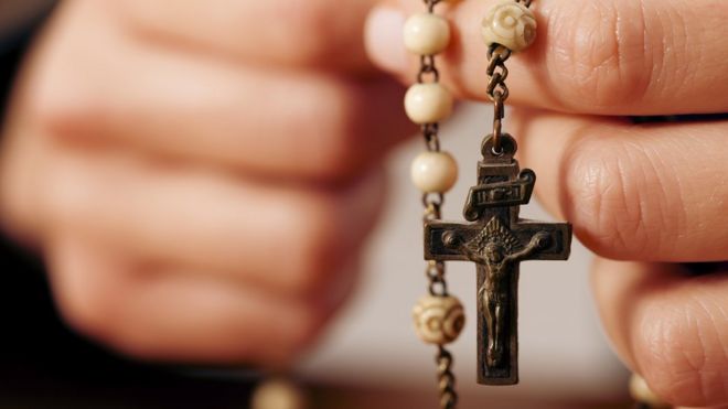 A woman holding rosary beads