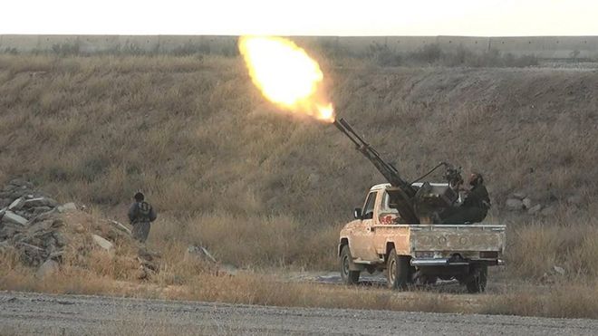An Islamic State militant fires an anti-aircraft gun from the back of a pickup truck in Hassakeh (image from June 2016)
